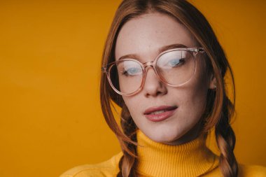 Serene Kafkas kadın, gözlüklü sessiz stüdyo resmi, temiz gözlükler, hardal sarısı balıkçı yaka, örgülü saç, yumuşak...