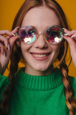 Beyaz kadın, renkli güneş gözlüklerini ayarlıyor. Yakın portre, el kameraları, parlak pullu lensler, kendinden emin.