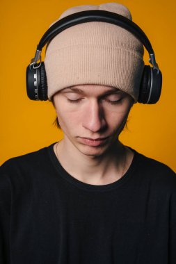 Serene Kafkas adam gözleri kapalı, yakın çekim yüz çerçeveli bere ve kulaklıklar, yumuşak stüdyo ışığı, tefekkür