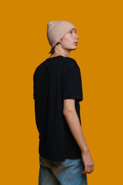 Portakallı Fasulye Giyen Genç Adam. Black Shirt ve Denim Jeans, yan yana durun.