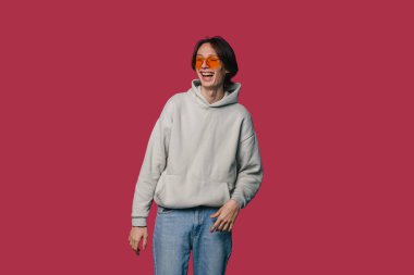 Genç Adam Yürüyen Güneş Gözlüğü Kırmızı Arkaplan, Gizli Stüdyo Çekimi Neşeli İfade Yakalama, Eller Sallanıyor,