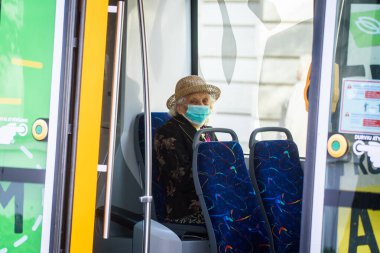 RIGA, LATVIA. 8 Ekim 2020. Seçici odak fotoğrafı. Tramvayda yüz koruyucu maske takan biri..