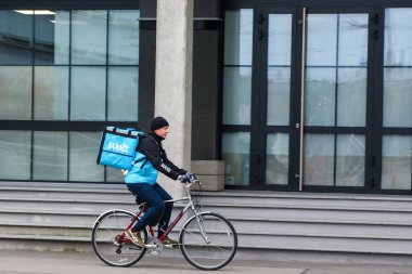 RIGA, LATVIA. 12 Kasım 2020. Riga City 'de Wolt şirketinin yemek dağıtım işçisi. Wolt, gıda dağıtım platformuyla tanınan Fin teknoloji şirketidir..