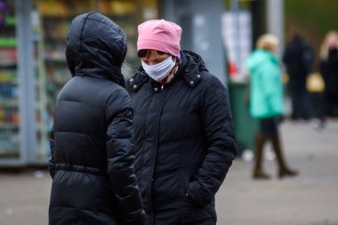 RIGA, LATVIA. 15 Kasım 2020. Sokakta yüz koruyucu maske takan biri..