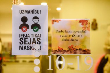 RIGA, LATVIA. 19th November 2020.  Attention, Entrance only with face protective masks. clipart