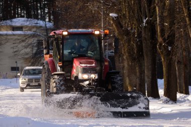 Bebeğim, LATVIA. 31 Ocak 2021. Seçici odak fotoğrafı. Traktör kar temizliyor.