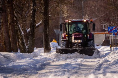 Bebeğim, LATVIA. 31 Ocak 2021. Seçici odak fotoğrafı. Traktör kar temizliyor.