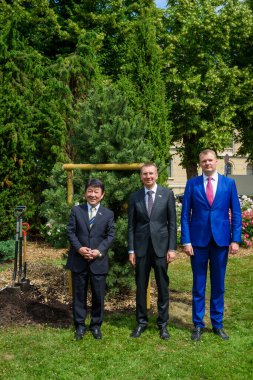 RIGA, LATVIA. 2 Temmuz 2021. Riga City Belediye Başkan Yardımcısı Toshimitsu Motegi, Japonya Dışişleri Bakanı Edgars Rinkeviç (C) ve Edvards Smiltens (R), ortak ağaç dikme etkinliğine katıldılar..