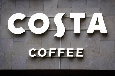RIGA, LATVIA. 5 Aralık 2025. Seçici odak fotoğrafı. Costa Coffee logosu. Costa Coffee, merkezi Dunstable, Bedfordshire 'da bulunan çok uluslu bir İngiliz kahve ve perakende satış şirketidir..