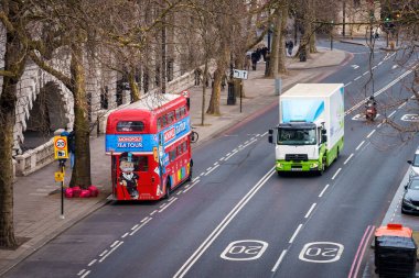 Londra, İngiltere. 15 Şubat 2025. İkonik kırmızı çift katlı otobüsler ve Londra şehir trafiğinde beyaz bir minibüs..