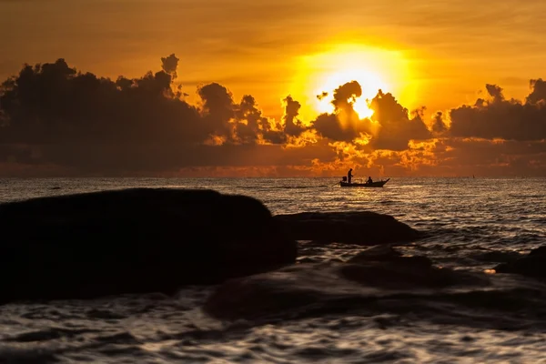 Un petit bateau au coucher du soleil sur la mer — Photo