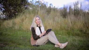 Tablet bilgisayar dışında ile oturan genç kadın