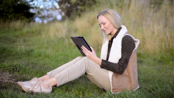 Junge Frau benutzt Tablet-Computer und lächelt — Stockvideo