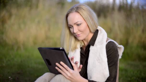 Mujer joven atractiva usando tableta de computadora fuera — Vídeos de Stock
