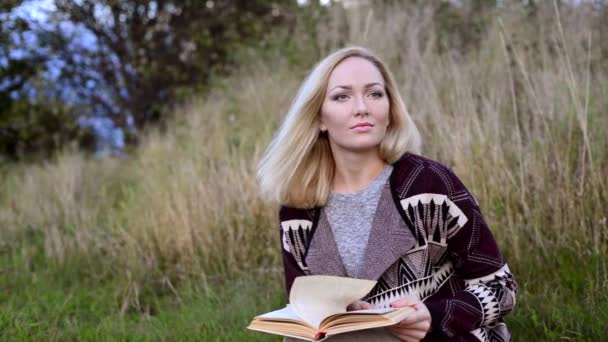 Ung kvinna. läsa bok och wathing på kameran — Stockvideo