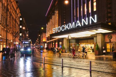 Helsinki, Finlandiya - 26 Ekim 2020: Tramvaylar Aleksanterinkatu caddesinde hareket ediyor. Yağmurlu sonbahar akşamı.