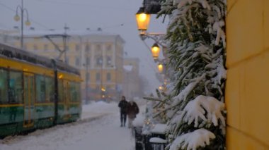 Güçlü kar fırtınası sırasında Aleksanterinkatu Caddesi. Tramvay caddede hareket ediyor. Karla kaplı ladin dallarıyla süslenmiş pencereler. Helsinki, Finlandiya 'daki güzel Noel atmosferi.