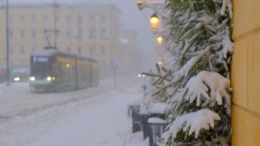 Güçlü kar fırtınası sırasında Aleksanterinkatu Caddesi. Tramvay caddede hareket ediyor. Karla kaplı ladin dallarıyla süslenmiş pencereler. Helsinki, Finlandiya 'daki güzel Noel atmosferi.