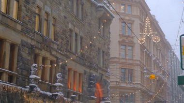 Helsinki, Finlandiya - 12 Ocak 2021: Aleksanterinkatu sokağı kar yağışı sırasında Noel için dekore edildi.