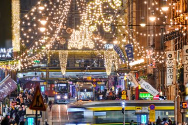Helsinki, Finlandiya - 22 Aralık 2020: Kentin merkezinde Noel süslenmiş Aleksanterinkatu caddesi. Şehirdeki en ünlü cadde. Sokakta hareket eden tramvaylar.