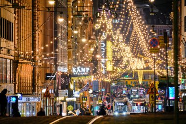 Helsinki, Finlandiya - 22 Aralık 2020: Kentin merkezinde Noel süslenmiş Aleksanterinkatu caddesi. Şehirdeki en ünlü cadde. Sokakta hareket eden tramvaylar.