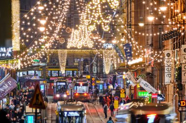 Helsinki, Finlandiya - 22 Aralık 2020: Kentin merkezinde Noel süslenmiş Aleksanterinkatu caddesi. Şehirdeki en ünlü cadde. Sokakta hareket eden tramvaylar.