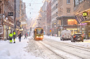 Helsinki, Finlandiya - 12 Ocak 2021: Aleksanterinkatu Caddesi, şiddetli kar fırtınası sırasında. Tramvay yolda ilerliyor..