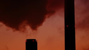 CHP bitki borularının kırmızı gün batımında dumanlı yakın görüntüsü.