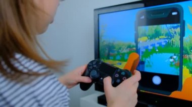 Espoo, Finlandiya - 25 Şubat 2021: Sony Playstation 4 kontrolörüyle Apple TV Arcade 'de Alba video oyunu oynayan kız