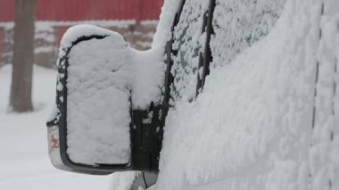 Finlandiya 'da şiddetli kar yağışı sırasında arabanın karla kaplı büyük aynası