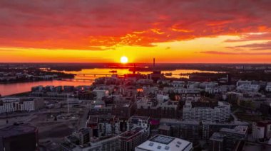Helsinki 'nin Jatkasaari mahallesinin muhteşem turuncu günbatımında hava manzarası. Hava hızlandırılmış video.