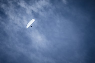 Mavi gökyüzünde süzülen paraglider
