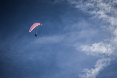 Mavi gökyüzünde süzülen paraglider