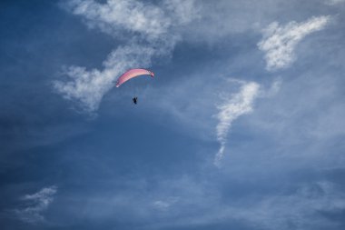 Mavi gökyüzünde süzülen paraglider