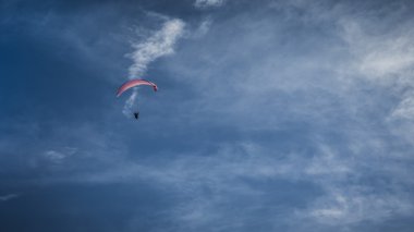 Mavi gökyüzünde süzülen paraglider