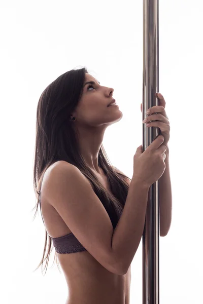 Schöne junge Frau posiert an der Stange — Stockfoto