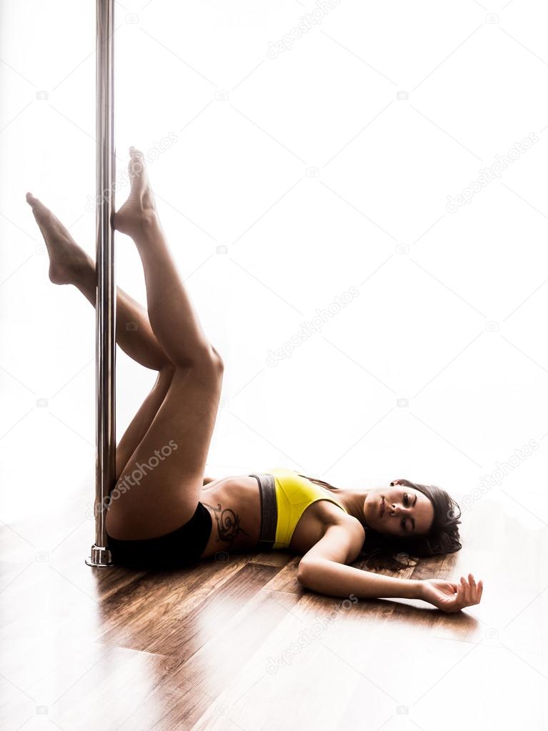 Beautiful young woman posing at pole