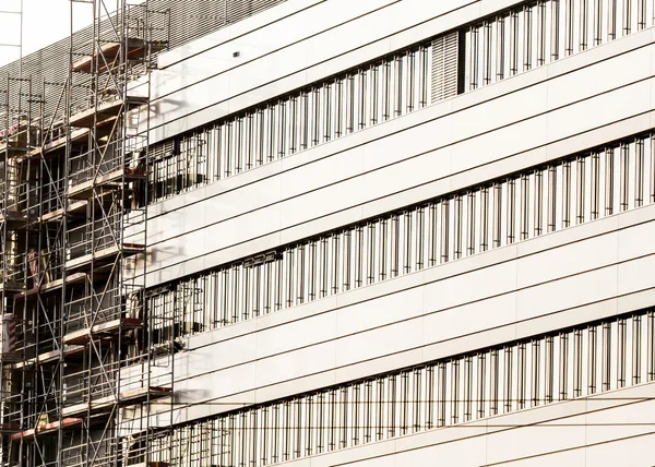 Fasad av modern byggnad med byggnadsställningar — Stockfoto