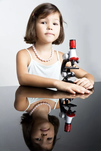 Little girl and a microscope — Stock Photo, Image