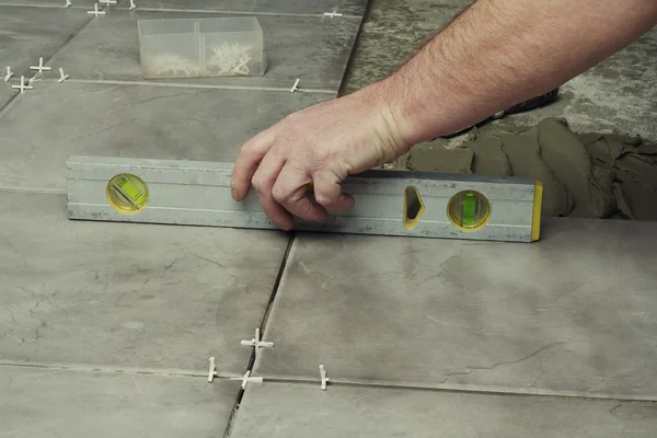 Renovation - construction worker laying tile — Stock Photo, Image