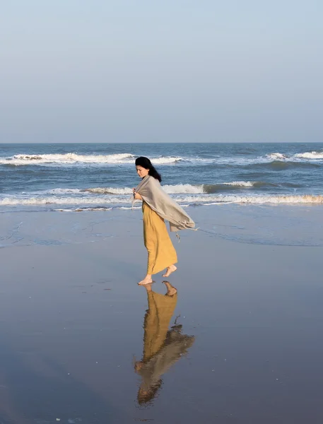 Donna che cammina lungo la spiaggia — Foto Stock