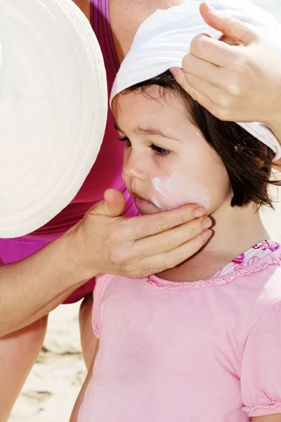Mother applying sunblock on her daughter — Stock Photo, Image