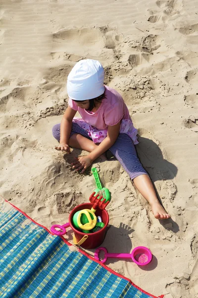 Çocuk kumsalda kumla oynuyor. — Stok fotoğraf