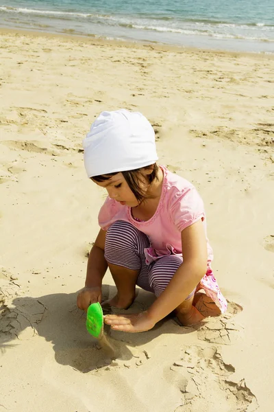 Dziecko bawiące się piaskiem na plaży — Zdjęcie stockowe