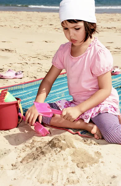 Çocuk kumsalda kumla oynuyor. — Stok fotoğraf