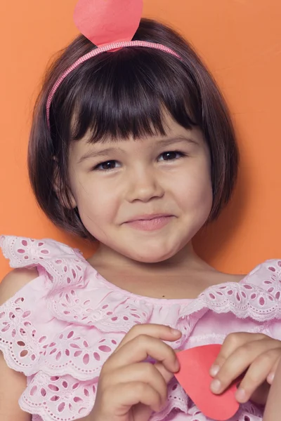 Little girl and red hearts. — Stock Photo, Image