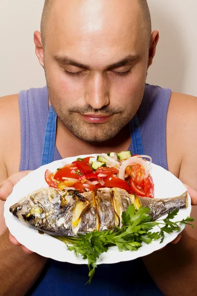 Chef shows sea bream fish with lemon, parsley,garlic. — Stock Photo, Image