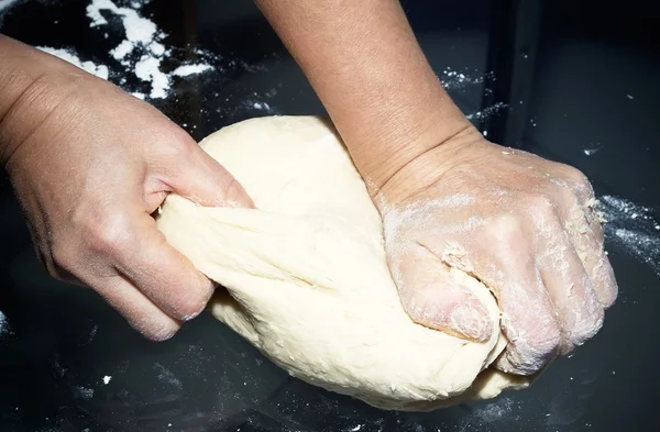Mãos amassando uma massa de farinha — Fotografia de Stock