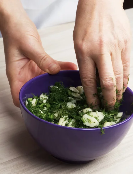 Kvinnliga händer dill blandat med vitlök — Stockfoto