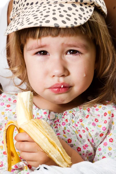 Маленькая девочка ест банан — стоковое фото